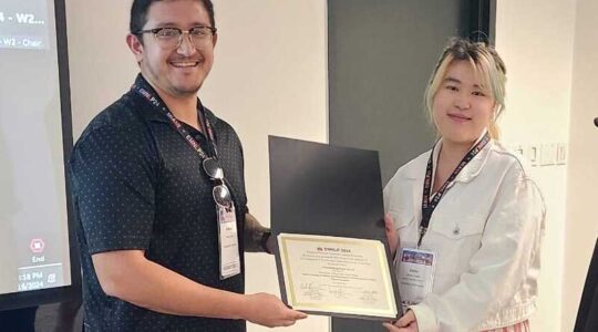 Anthony Sicilia (left) poses with an outstanding paper award.