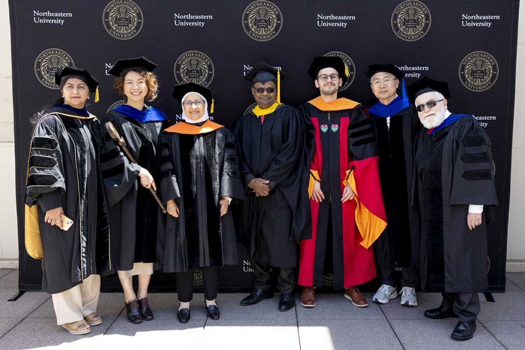 Khoury faculty at Northeastern Silicon Valley pose for a photo while wearing graduation regalia