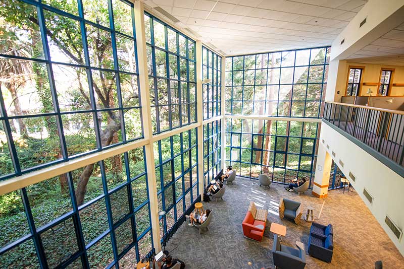 Students study in a large atrium at Northeastern Oakland's library